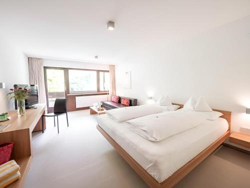 布雷根茨沃尔德地区奥奥乌克罗恩酒店的一间白色的大卧室,配有两张床和一张书桌