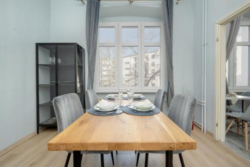 弗罗茨瓦夫Spacious 3-Bedroom Apartment Plac Grunwaldzki Wrocław by Renters的一间带木桌和椅子的用餐室