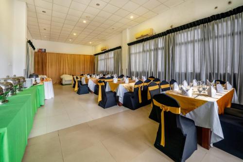 瓦都瓦Nirmala Hotel的宴会厅配有长桌子和椅子