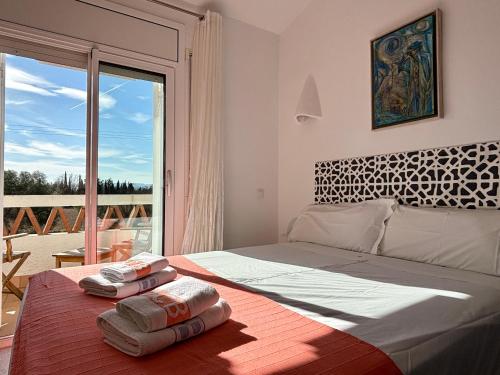 埃斯塔蒂特Casas Plus Costa Brava的一间卧室配有一张大床和两条毛巾