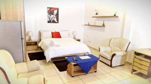 罗安达CASA NATALIA - Guesthouse的一间卧室配有一张床、两把椅子和一张桌子