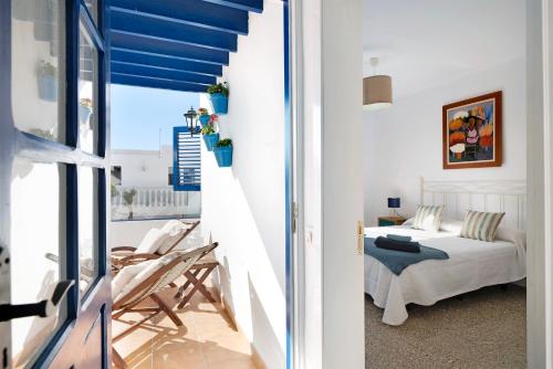 宏达海滩La Chinija的一间卧室配有一张床,阳台拥有蓝色的天花板