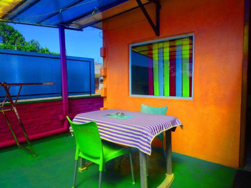 哈顿玫瑰园住宿加早餐旅馆的阳台配有桌椅和色彩缤纷的墙壁
