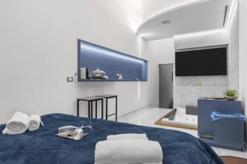巴勒莫I Cappuccini Suite的一间卧室配有一张床、一个浴缸和一台电视。