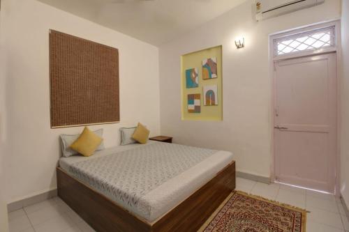 卡兰古特Calangute Cosy 1 bhk Apartment的一间卧室设有床、窗户和门