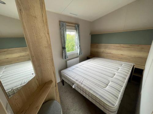 斯凯格内斯Dainville Caravan Park的一间小卧室,配有床和窗户