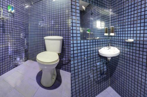 巴加Comfort Holiday Home的蓝色瓷砖浴室设有卫生间和水槽