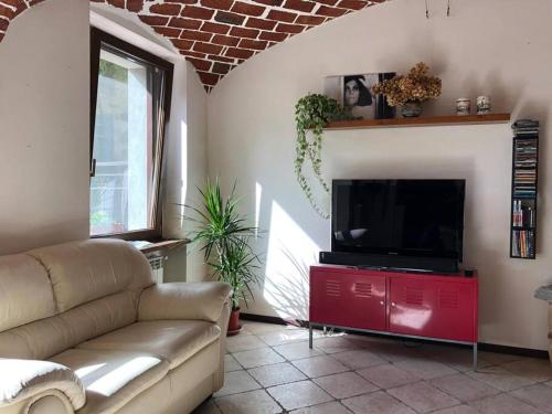 Serralunga di CreaCa' Cuore in Monferrato的带沙发和平面电视的客厅