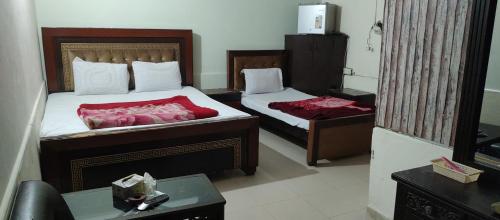 木尔坦Hotel New Star的酒店客房设有两张床和一张桌子。