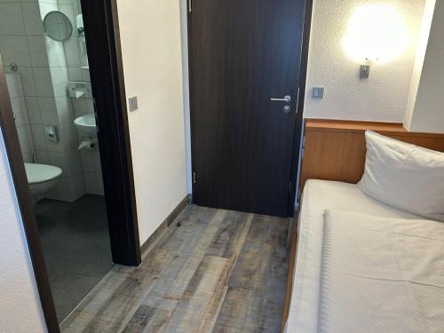 纽伦堡法克曼酒店的一间卧室配有一张床,浴室设有卫生间