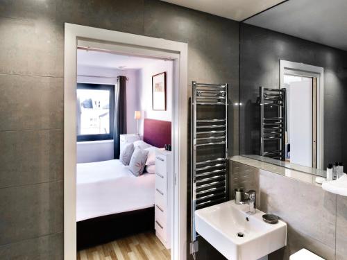剑桥Your Space Apartments - Eden House的浴室设有床、水槽和镜子