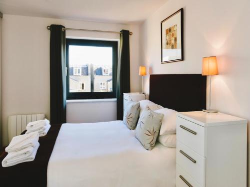 剑桥Your Space Apartments - Eden House的卧室配有白色的床和窗户。