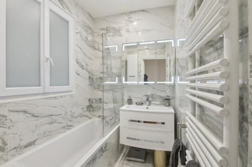 巴黎Élégance parisienne près des Champs-Élysées的白色的浴室设有水槽和淋浴。