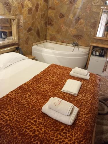 卡拉维塔Ζachlorou Mood的一间卧室配有床、浴缸和毛巾