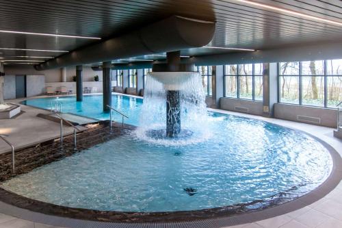 诺德克豪特诺德韦克列文霍斯特会议中心NH酒店的一座大楼内带喷泉的大型游泳池