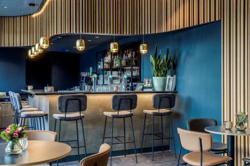 诺德克豪特诺德韦克列文霍斯特会议中心NH酒店的餐厅里设有蓝色墙壁和凳子的酒吧
