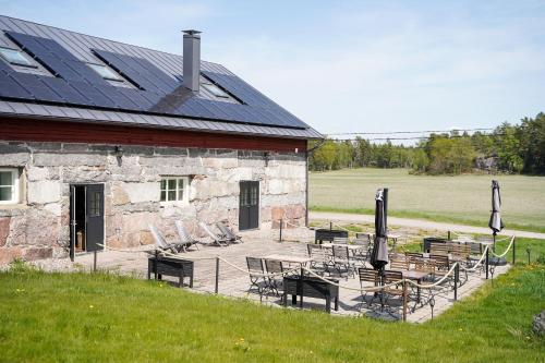 瑙沃斯塔尔贝肯纳古酒店的一座带桌椅和太阳能屋顶的建筑