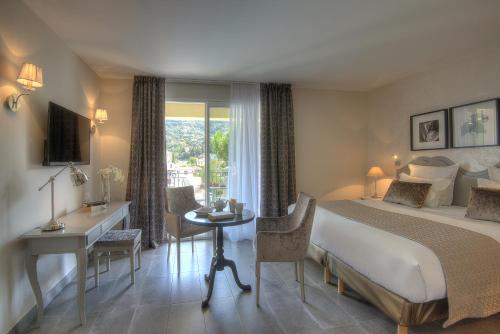 戛纳巴斯蒂奥利佛莱酒店的配有一张床、一张书桌和一扇窗户的酒店客房