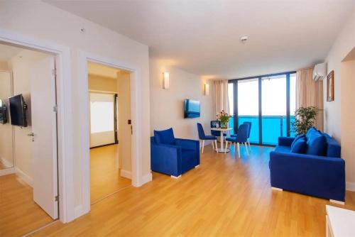 巴统ORBI CiTY-sea view aparthotel的客厅配有蓝色的沙发和桌椅