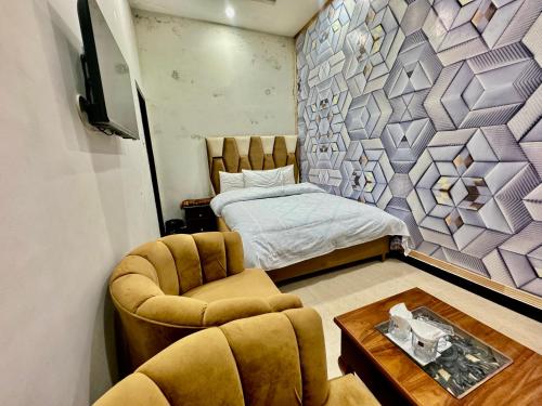 伊斯兰堡Al Atif Hotel的一间卧室配有一张床、两把椅子和一张桌子