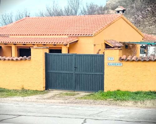 罗德里戈城Casa rural Los Barreros的前面有蓝色门的黄色房子