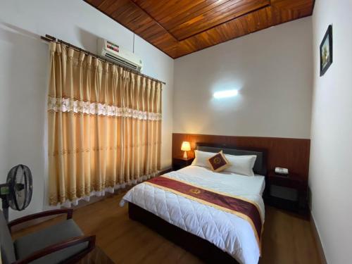 Nhà Nghỉ Phương Chi Mạo Khê的一间卧室配有床和带窗帘的窗户