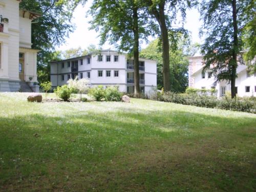 诺伊霍夫Haus am Buchenpark Remise 19的前面有草地庭院的白色大房子