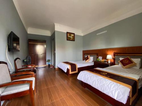 Nhà Nghỉ Phương Chi Mạo Khê的酒店客房,配有两张床和椅子