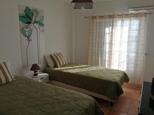 卡巴纳斯·德·塔维拉Apartamento Vista Mar的一间卧室设有两张床和窗户。