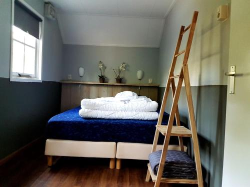 奥特罗Tiny House de Berken的一张带蓝色毯子和楼梯的床