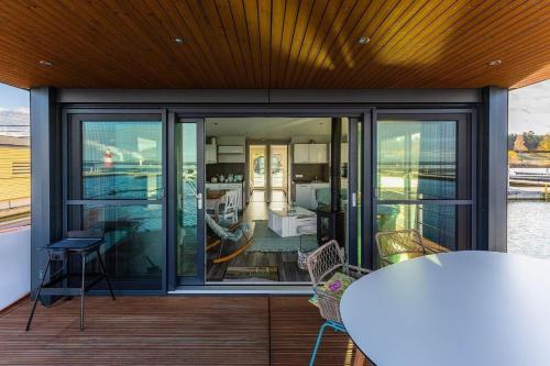 KlittenHausboot Paradise的阳台设有玻璃门和桌椅。