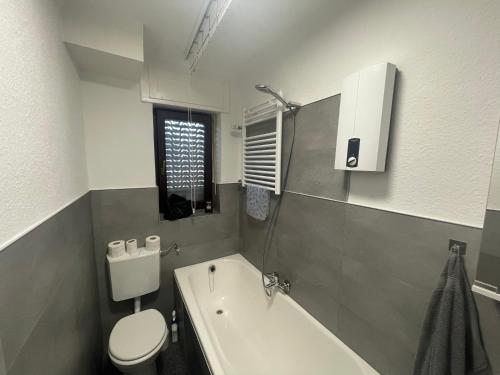 阿尔斯多夫Apartment im Herzen von Alsdorf的浴室配有白色卫生间和浴缸。