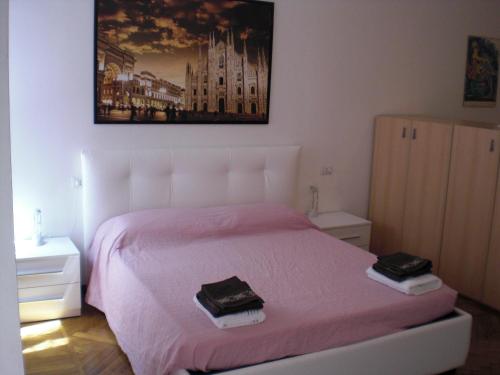 米兰Flat in Milan 1的一间卧室配有粉红色的床和2条毛巾