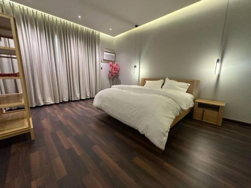 Al Başarتربل فور سويت - شقة في فيلا的卧室配有一张白色的大床,铺有木地板