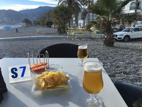 拉海瑞德拉HH Apartamento La Herradura Playa的一张桌子,上面放着两杯啤酒和薯片