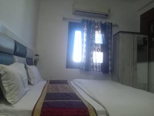 阿姆利则Gurjeet Hotel by Naavagat的白色的卧室设有床和窗户
