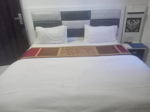 阿姆利则Gurjeet Hotel by Naavagat的一张带两个枕头的大白色床