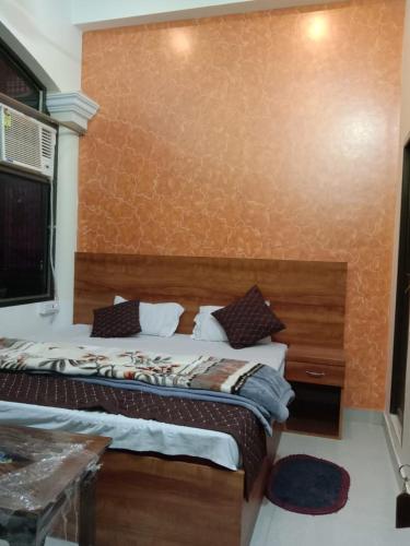 阿姆利则Gurjeet Hotel by Naavagat的一间卧室配有一张大床和木制床头板