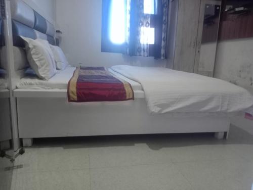 阿姆利则Gurjeet Hotel by Naavagat的一张大白床,坐在房间里
