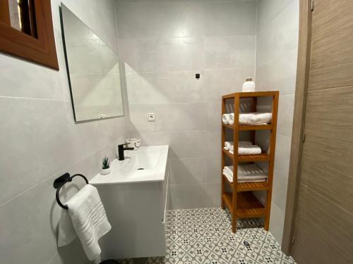 多列毛利诺斯M&H Torremolinos的浴室配有盥洗盆、镜子和毛巾