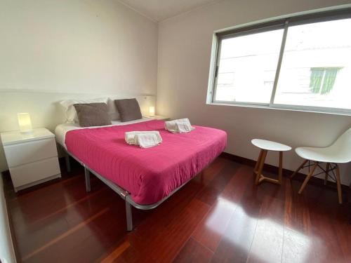 蓬塔德尔加达Luz's Retreat Apartment的一间卧室配有一张带粉色毯子的床