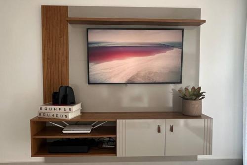 里约达欧特拉斯BlueCoast 205 Apartment的客厅的墙上配有电视