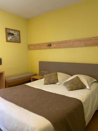 Bellignat美乐蒂酒店的一间卧室配有一张大床和两个枕头