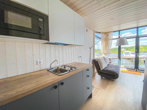 易克略Twin Boat的厨房配有水槽和带椅子的台面