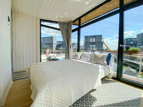 易克略Twin Boat的卧室设有白色的床和大窗户