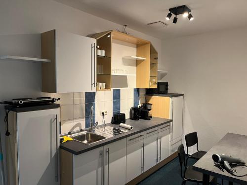 班贝格4rooms - Bamberger Gemütlichkeit的厨房配有白色橱柜和水槽