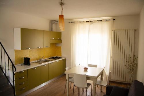 芬奇Appartamento a Vinci的厨房配有桌子、水槽和桌椅