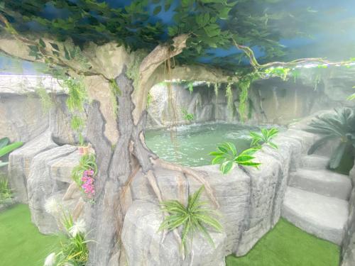 格拉纳达Futurotel Room Spa Garden的一座花园,花园内种有树木,设有池塘