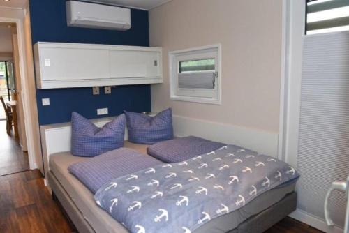 KlittenHausboot Dolce Vita的一间卧室配有一张带蓝色墙壁和紫色枕头的床