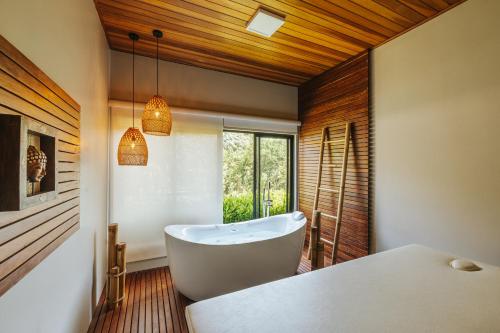 伊瓜苏LAS HOTEL BOUTIQUE的一间带白色浴缸和窗户的浴室
